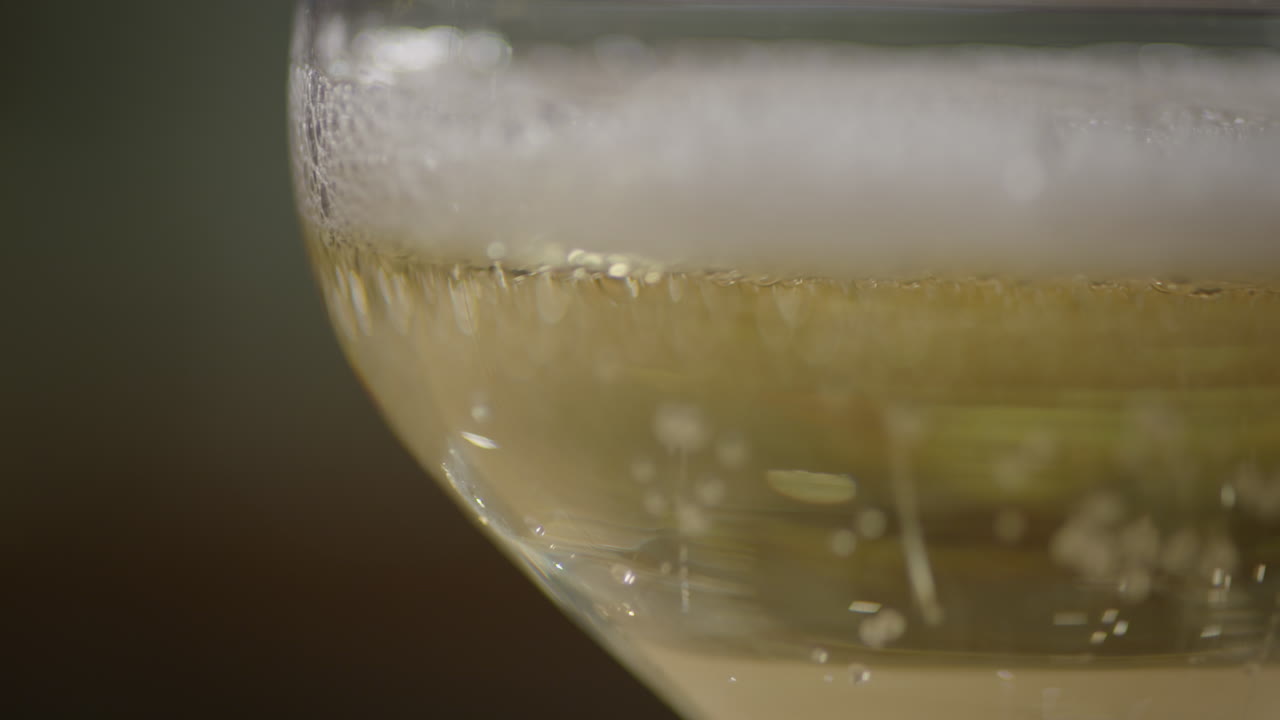 Versare champagne in un bicchiere a coppa.