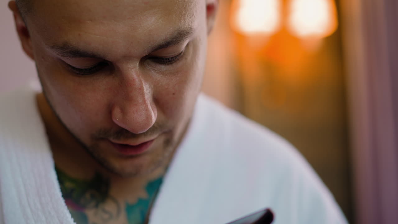 tipo con tatuajes graba mensaje de audio en el teléfono móvil