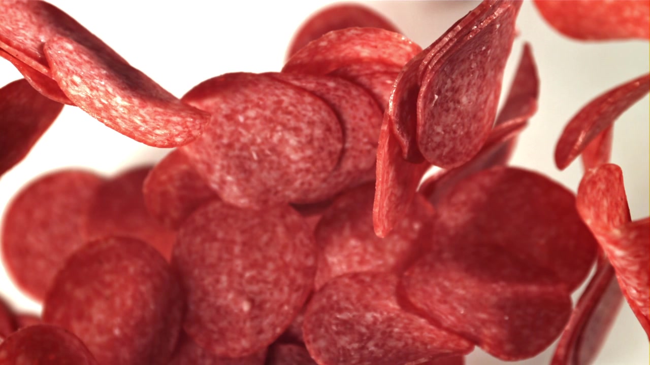 Deliziose fette di pepperoni che cadono al rallentatore