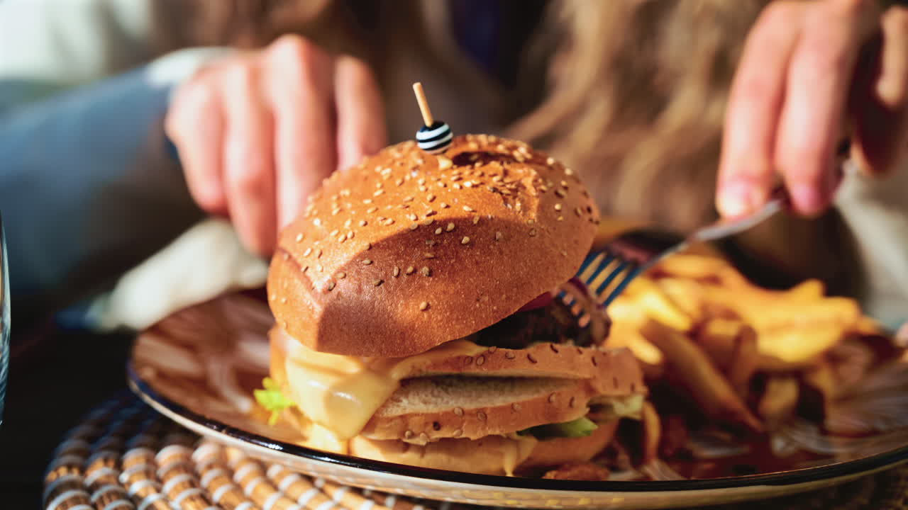 Gourmet burger served on a patterned plate in bright daylight, with blurred restaurant terrace in the background