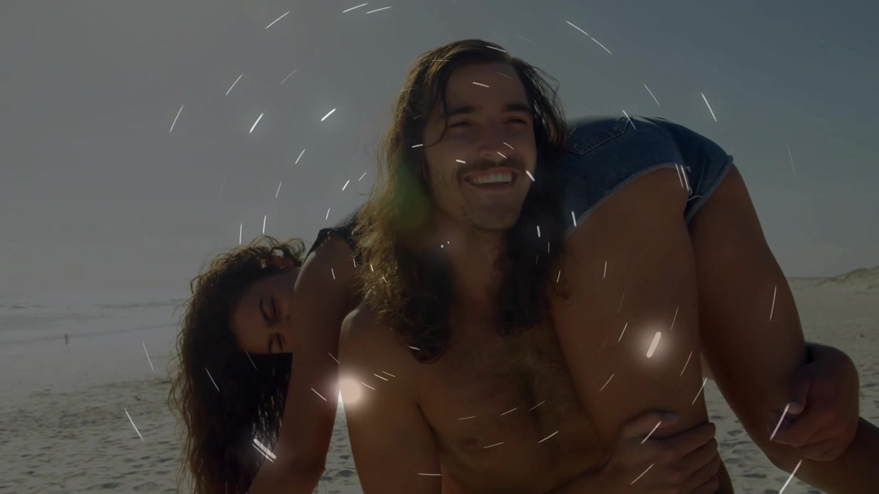 Uomo che porta una donna in braccio sulla spiaggia, stringendo la presa mentre appare un'interfaccia grafica, per il marketing turistico.