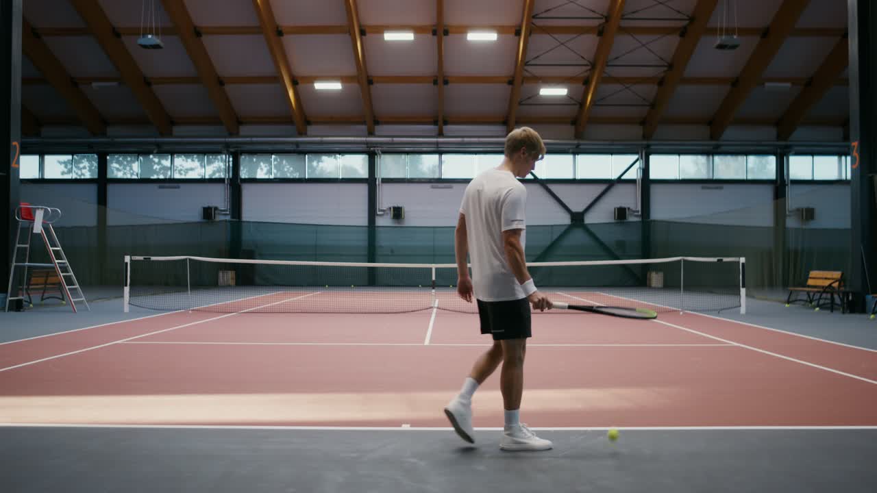 Man playing tennis indoors