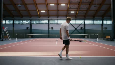 man playing tennis indoors