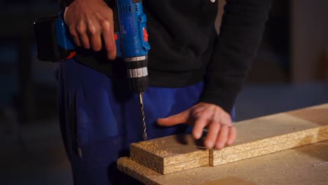 persona que utiliza un taladro eléctrico en la madera