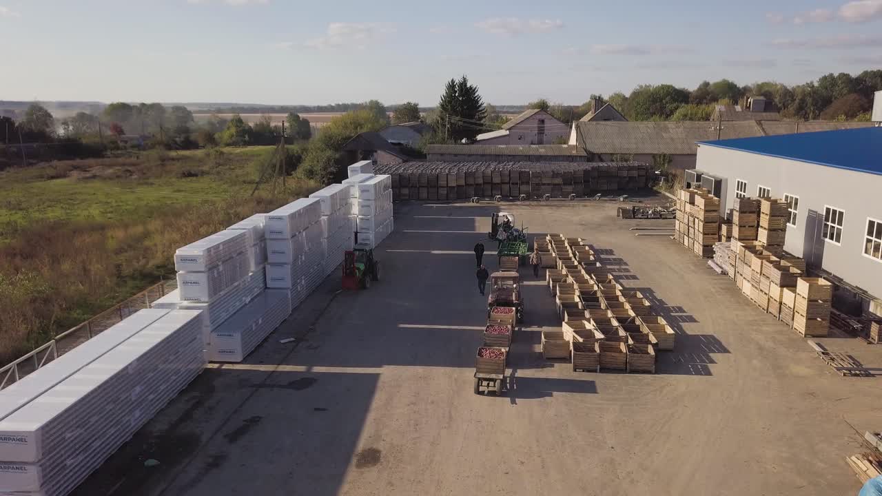 Forklift with apples in wooden crates. Aerial voew of modern concept of harvesting varietal apples and carrying forklift