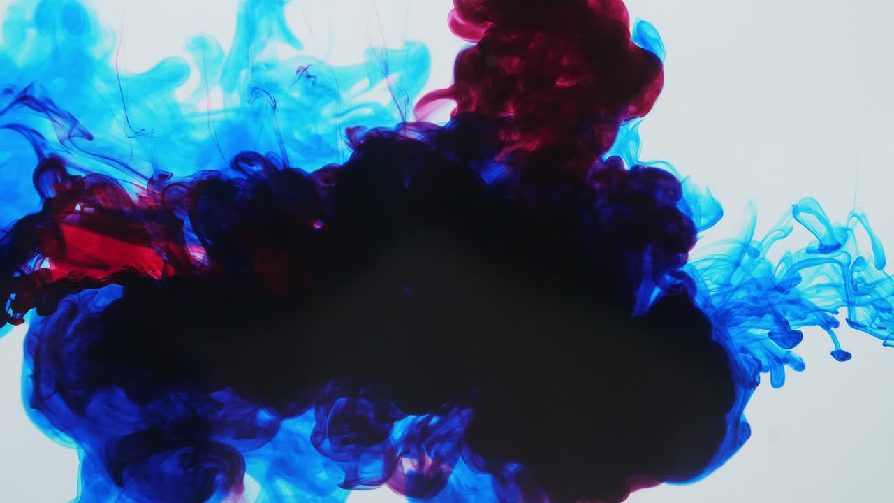 Blue And Red Ink Mixing In Water On A White Background