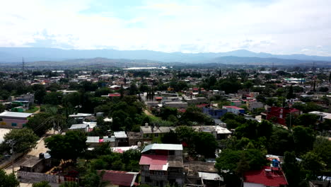 vista aérea de los suburbios de la ciudad de oaxaca en méxico, filmada por un dron con desplazamiento vertical y montañas al fondo