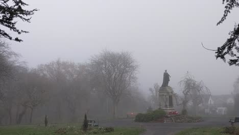 world war cenotaph memorial in park surrounded by mysterious misty fog with benches and autumn trees uk 4k