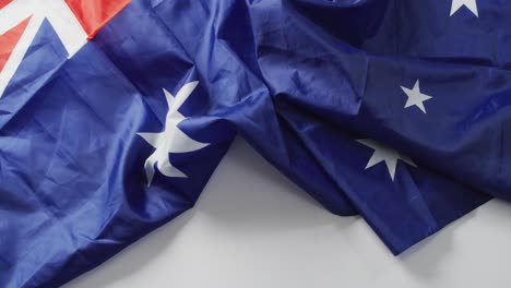 video of creased flag of australia lying on white background