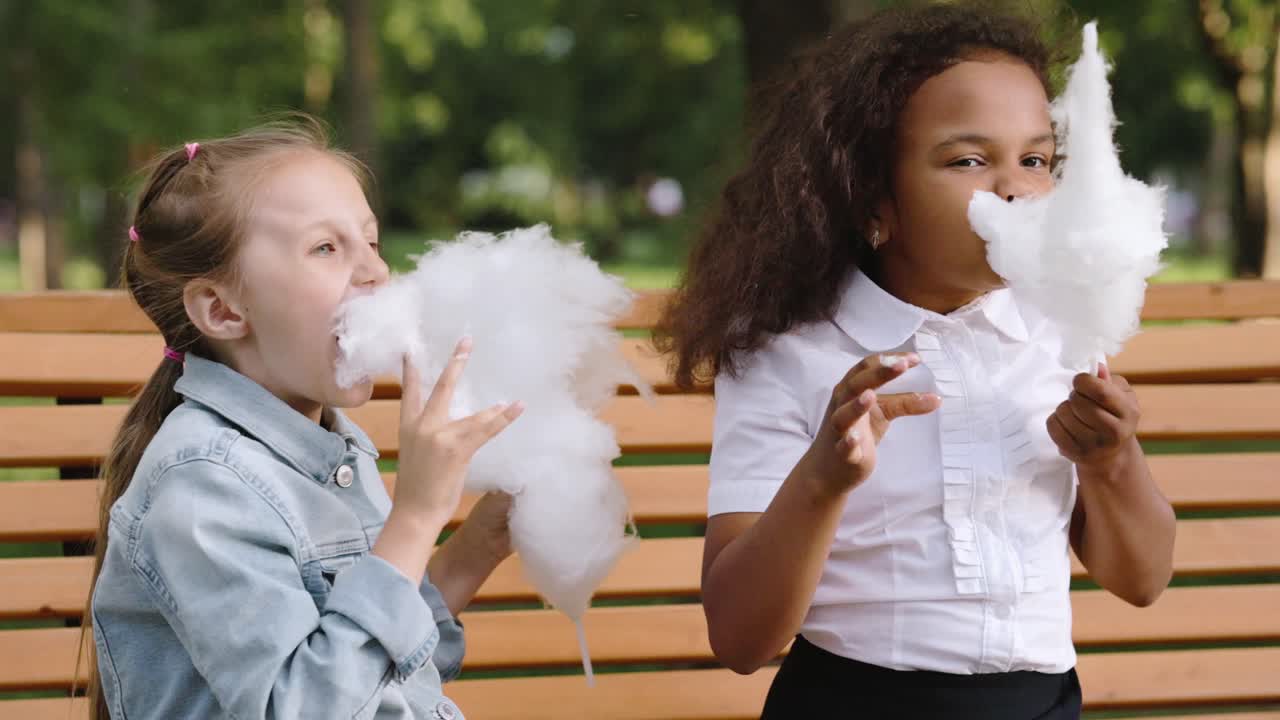 Due ragazze che mangiano zucchero filato in un parco