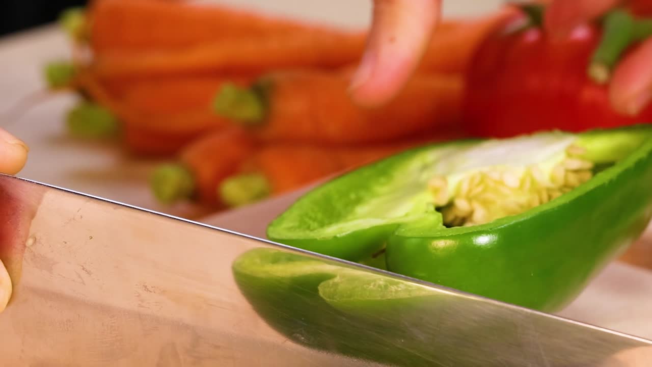 En kock använder en vass kniv för att skiva en livfull grön paprika