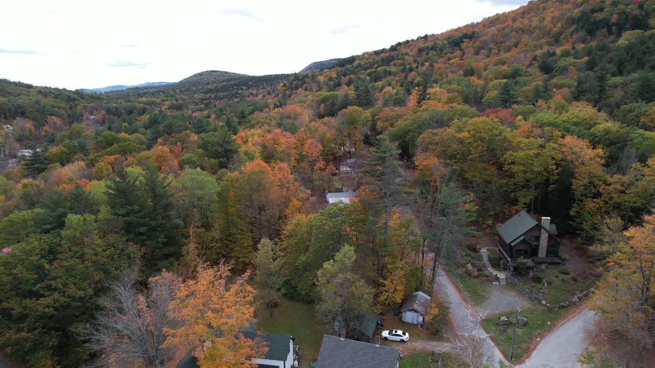 vista aérea de casas en un bosque colorido el día de otoño en el paisaje de newbury, área del lago sunapee, disparo de drones