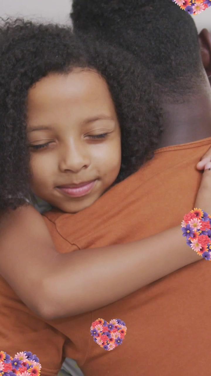 Animazione di cuori floreali su padre e figlia afroamericani che si abbracciano a casa