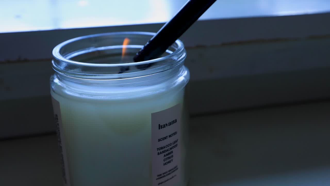 encendiendo una vela en un banco en una casa durante el invierno 4k