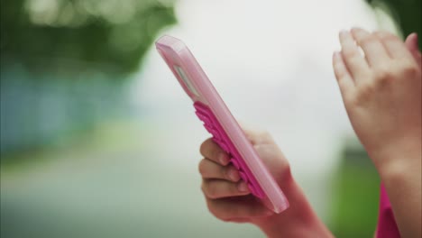 a close-up view of a child's hands using a colorful smartphone, showcasing engagement with technology and interactive digital experiences in a playful outdoor environment