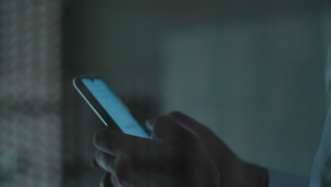 persona que utiliza un teléfono inteligente por la noche
