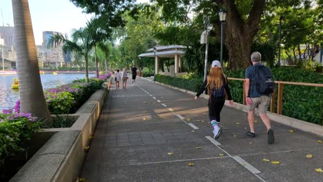 people exercising and strolling by the water