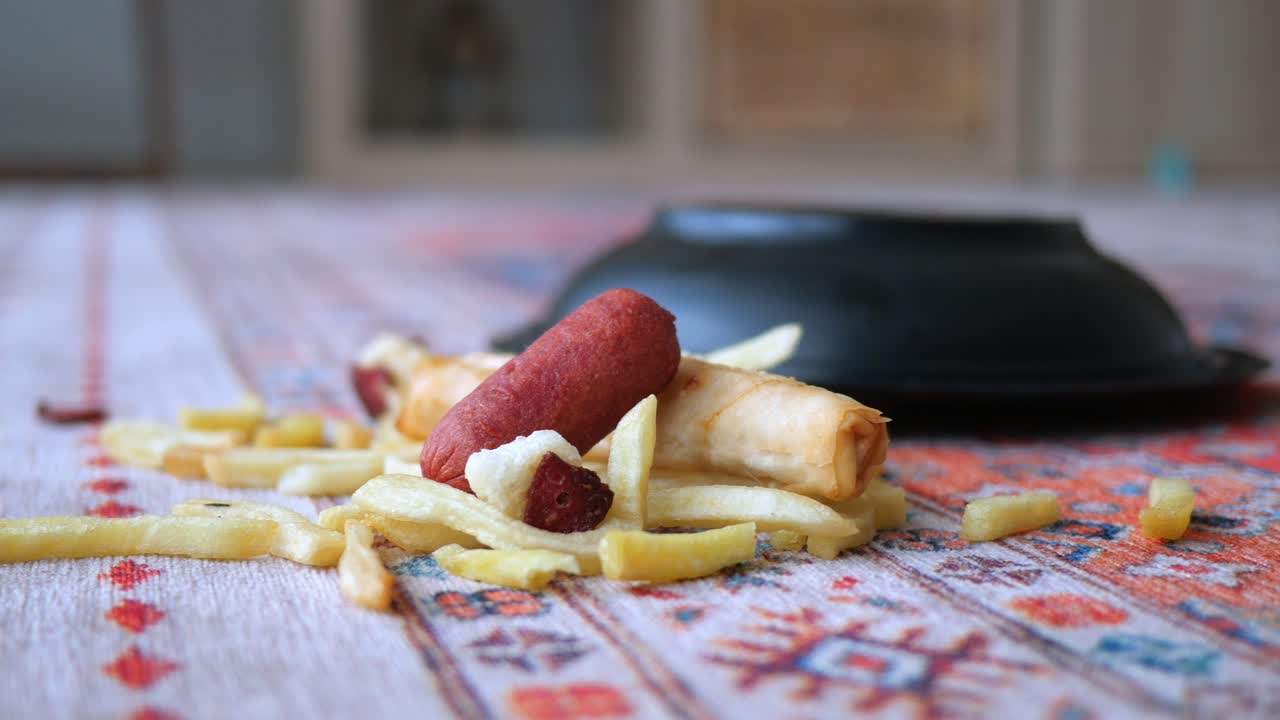 Primer plano de patatas fritas, salchicha y rollito de primavera sobre un mantel