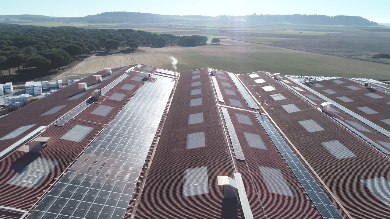 태양광 패널로 덮인 외딴 농장 건물의 지붕 위로 날아다니는 공중 드론, 친환경적이고 환경 친화적인 지속 가능한 농업을 위해 재생 에너지에 투자하는 농장