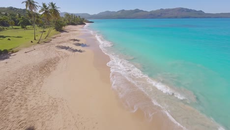 epic fpv drone flight over palms onto picturesque sandy beach and blue ocean