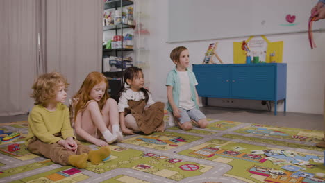 Cuatro-Niños-Sentados-En-Una-Alfombra-En-Un-Salón-De-Clases-En-Una-Escuela-Montessori