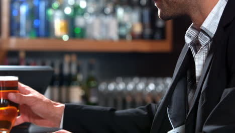 Businessman-drinking-beer-while-using-laptop