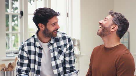 Loving-Same-Sex-Male-Couple-At-Home-In-Kitchen-Together