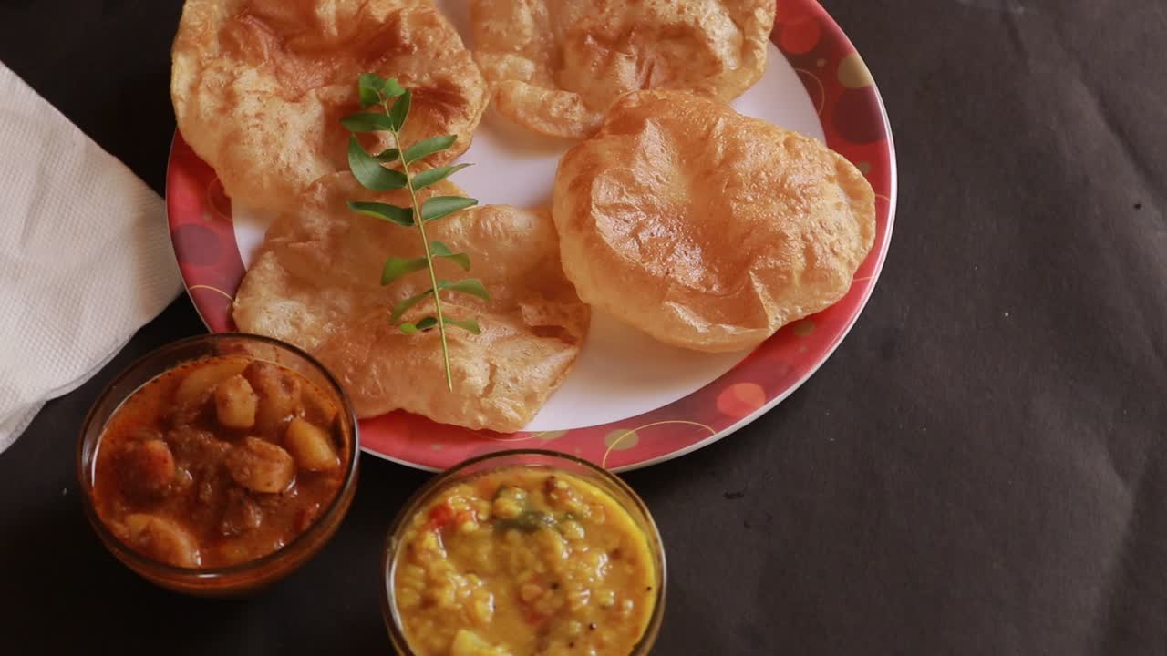 rotación de chole bhature o curry de garbanzos y puri frito servido en vajilla de terracota sobre el fondo de la espalda