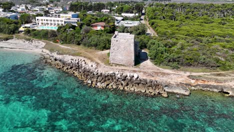 Langsame-Luftaufnahme-Eines-Einsamen-Strandes-Mit-Kristallklarem-Wasser,-Umgeben-Von-Grüner-Vegetation,-Apulien,-Italien