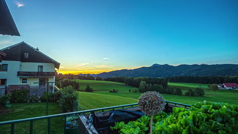 calm sunrise over a lush green field with a cozy house, clear sky transitioning from dawn to day