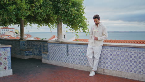 macho relajado disfrutando de vacaciones en un hermoso punto de vista. hombre sexy con una flor