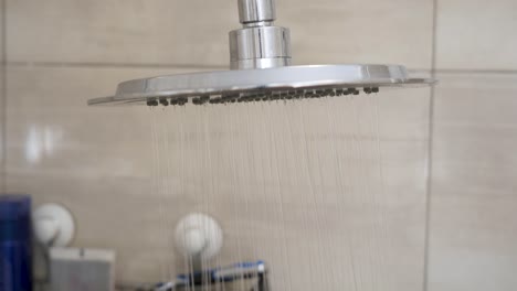 static shot of running cold water from the top down shower in bathroom