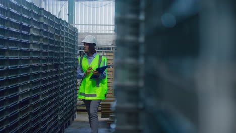 female warehouse supervisor inspecting blue supply boxes analysing shipment