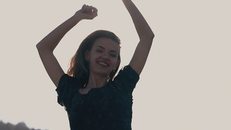 una chica alegre sonríe al sol en un día de primavera en cámara lenta