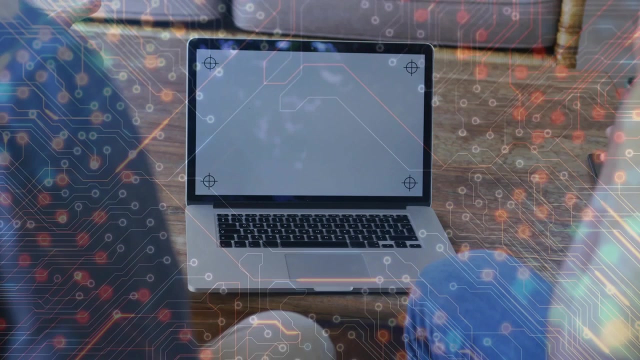 Two People Collaborating on a Laptop with Digital Circuit Overlay