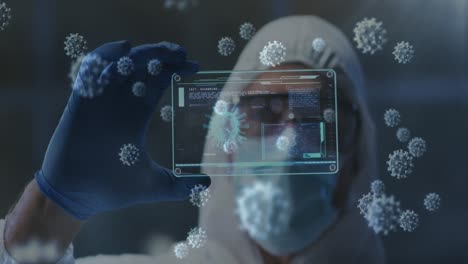 Covid-19-cells-floating-against-health-worker-holding-futuristic-screen-with-medical-data-processing