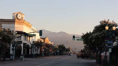 downtown covina, california at sunrise with a car driving and stable video.