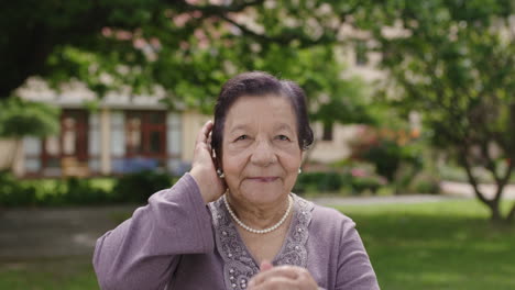 slow motion portrait of beautiful elegant elderly woman doing hair smiling at camera