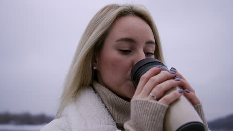 Blonde-girl-holding-hot-thermos