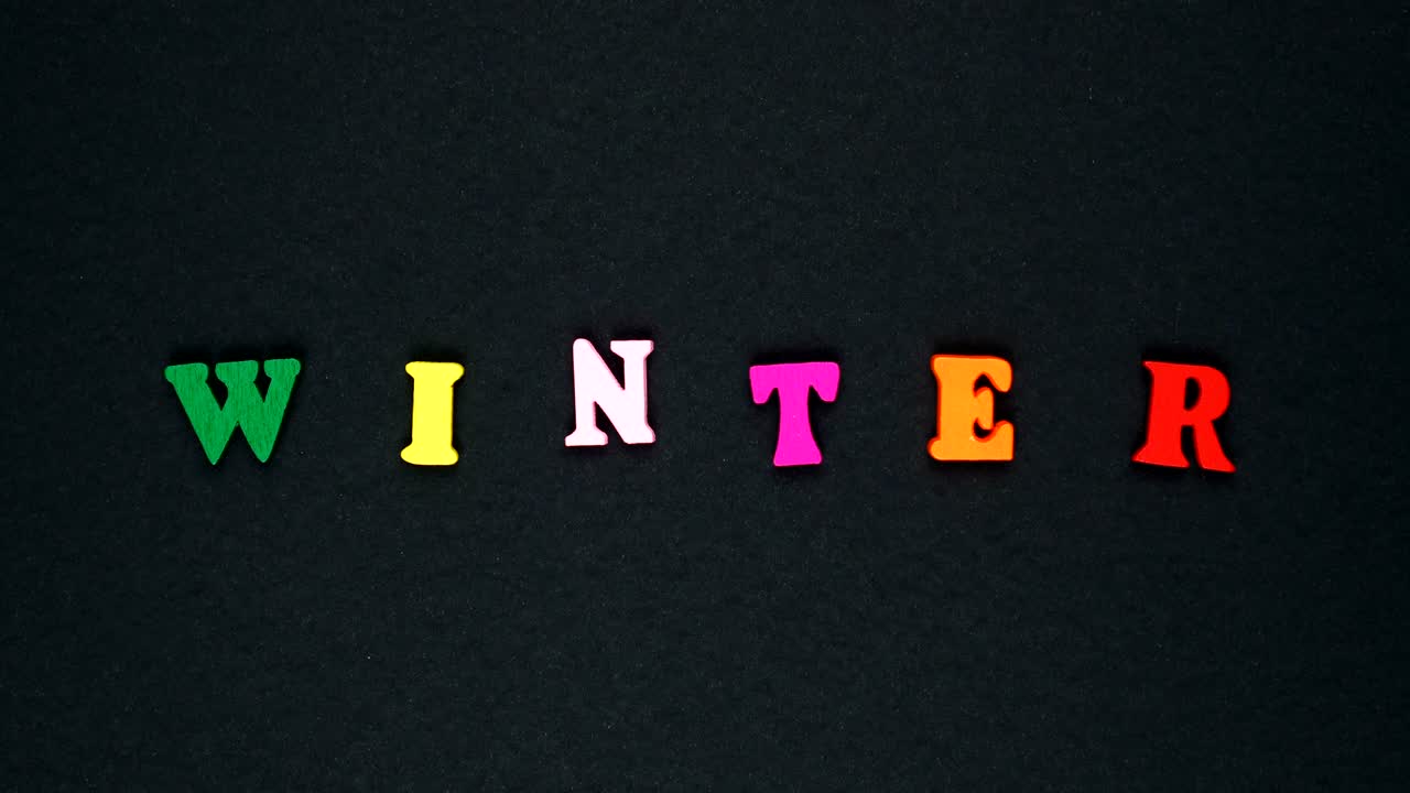 Parola "inverno" formata da lettere di legno multicolori. Loop di parole colorate.