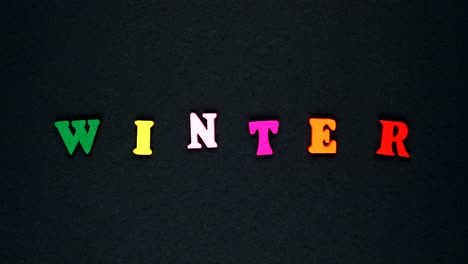 la palabra "invierno" está formada por letras de madera multicolores. palabras coloridas de bucle.