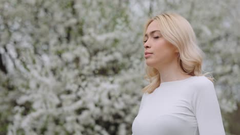 woman using nasal spray in a spring garden