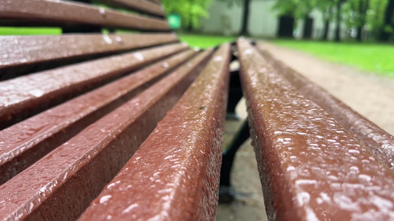 Raindrops fall on a park bench (4K 60fps)