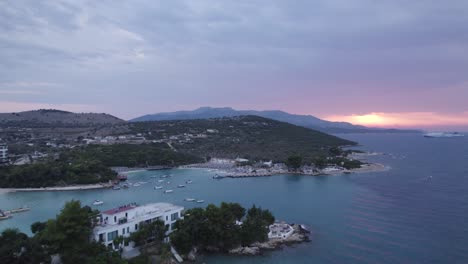 aerial evening view of sunset on horizon over ksamil coastline