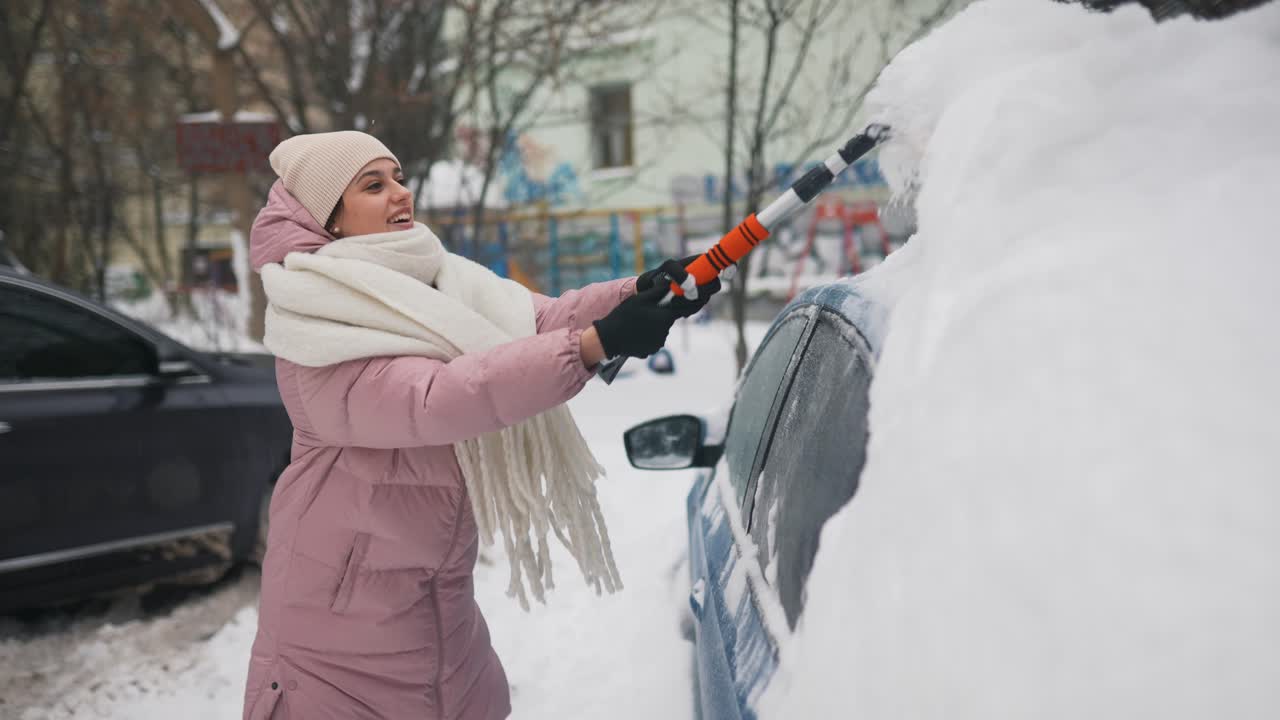 mujer quitando la nieve del coche en la ciudad de invierno