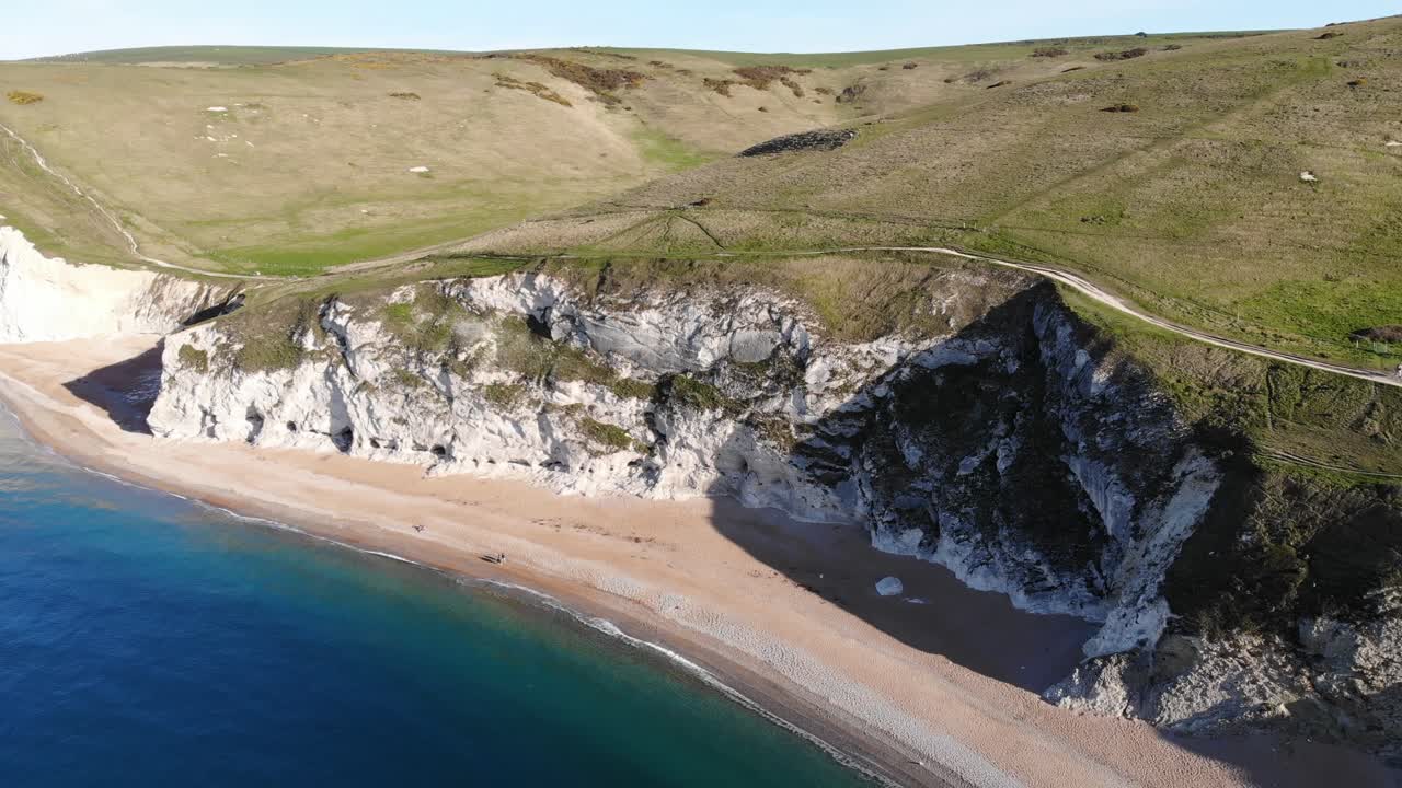 vista aérea de la playa vacía al lado de los acantilados de la colina en la puerta de durdle en dorset