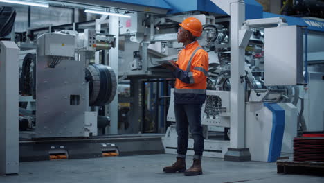 Engineer-use-tablet-computer-at-factory-wear-safety-uniform.-Industrial-concept