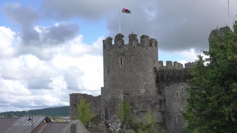 a majestic large stone castle towers over the medieval village of conwy wales