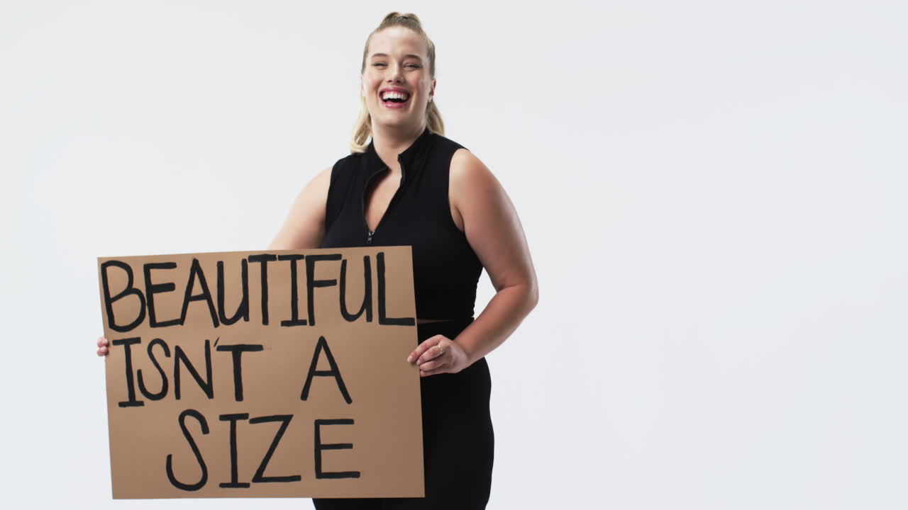 Young Caucasian plus size woman with light skin, blonde hair, and blue eyes holding poster, copy spa