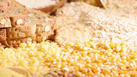 a variety of grains and breads displayed under warm lighting, showcasing textures and colors in a close-up arrangement